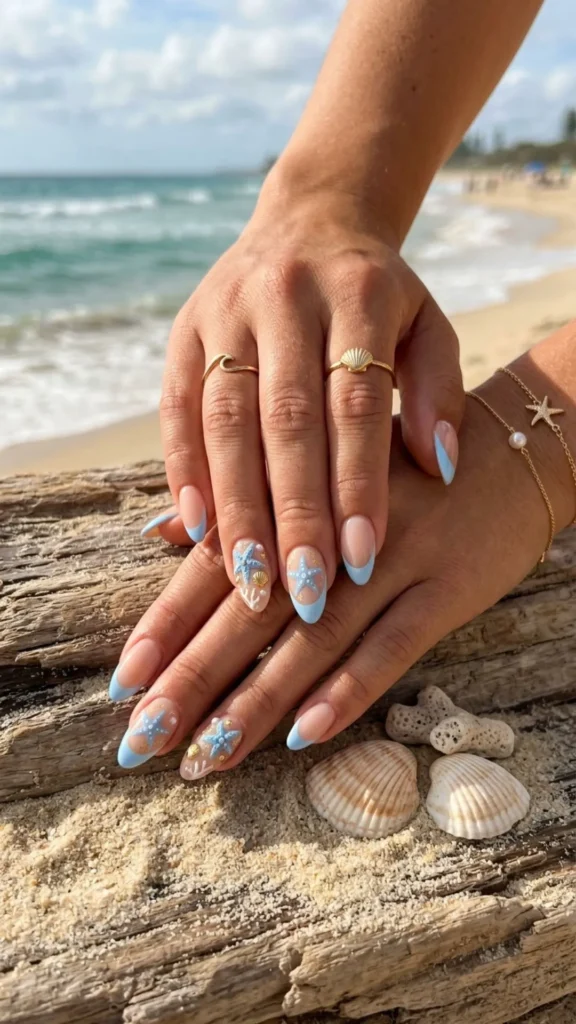 Baby blue French nails decorated with tiny starfish accents for a fresh coastal-inspired manicure.