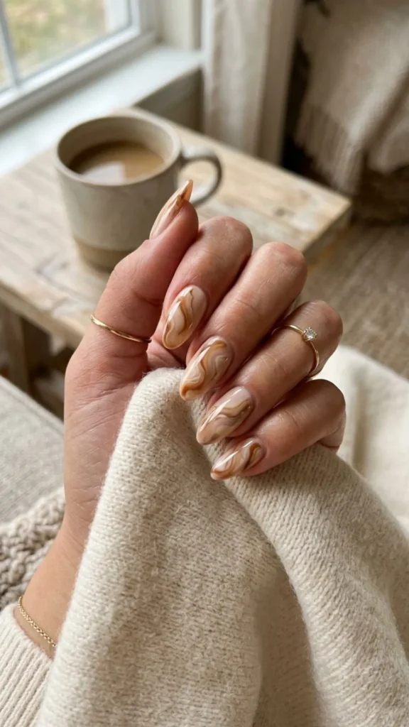 Chic caramel swirl marble nails in warm neutral tones for an elegant manicure.