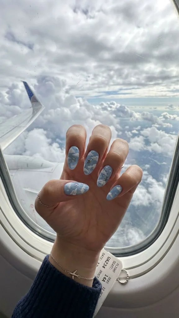 Dreamy cloudy sky flight nails featuring soft clouds and delicate airplane details.