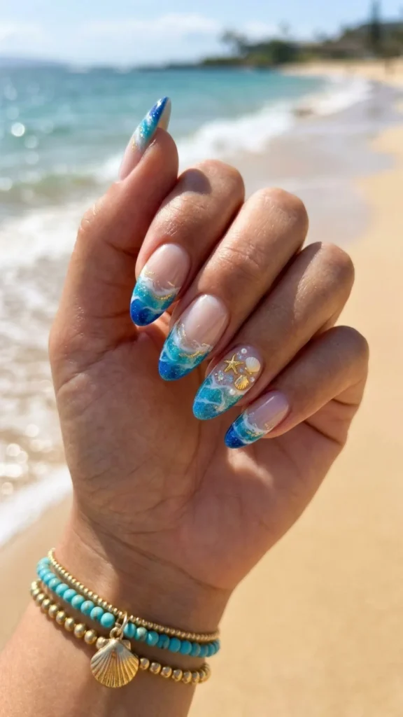 Glossy beach-inspired French tip ocean nails with shimmering blue waves, soft white tips, and a fresh coastal manicure look.
