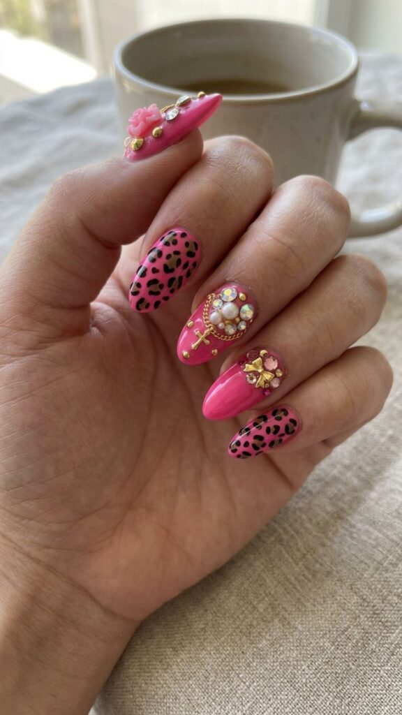 Hot pink leopard nails featuring bold animal print, sparkling charms, and glamorous 3D junk nail embellishments.