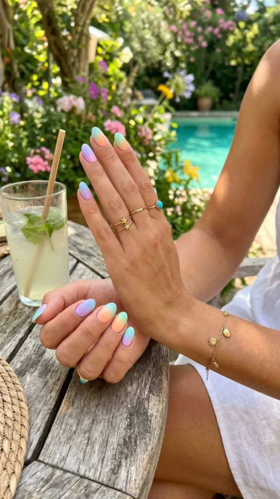Soft pastel ombre nails blending pink, blue, and lavender shades for a fresh summer manicure.
