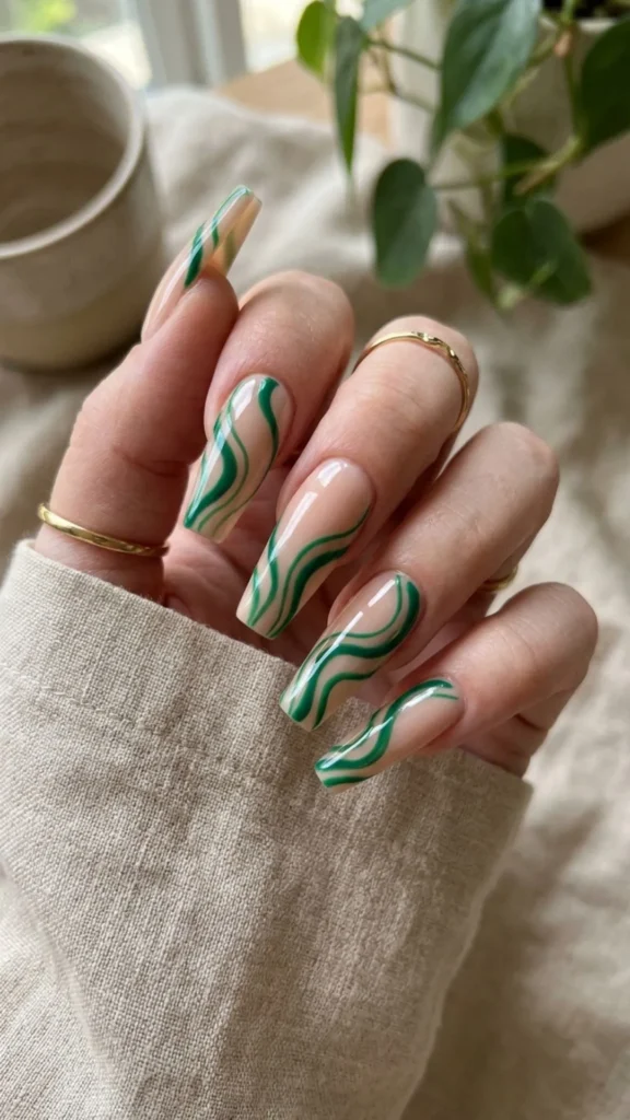 Green wave line nail art on coffin tips for a fresh and trendy manicure.