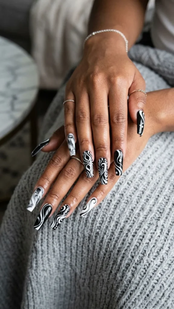 Monochrome swirl coffin nails featuring bold curves for a trendy manicure.