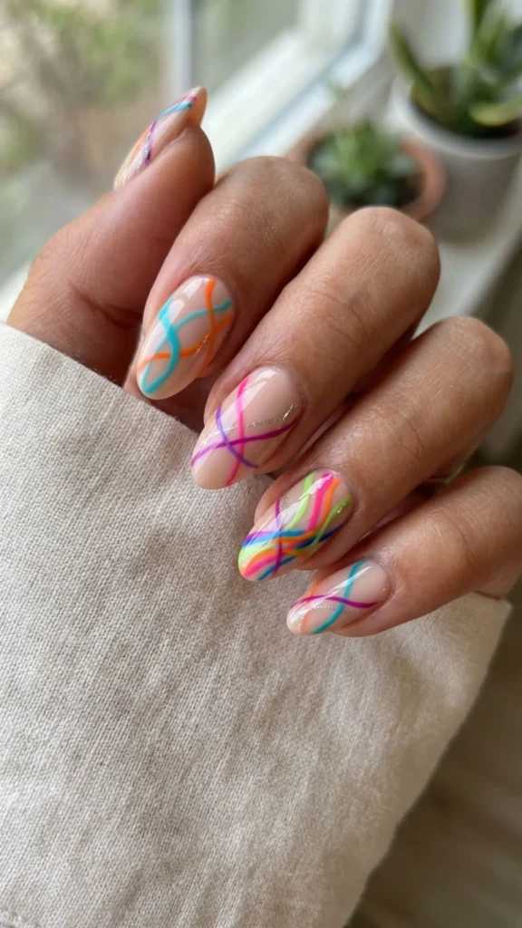 Vibrant abstract line nail art on a nude base for a chic modern manicure